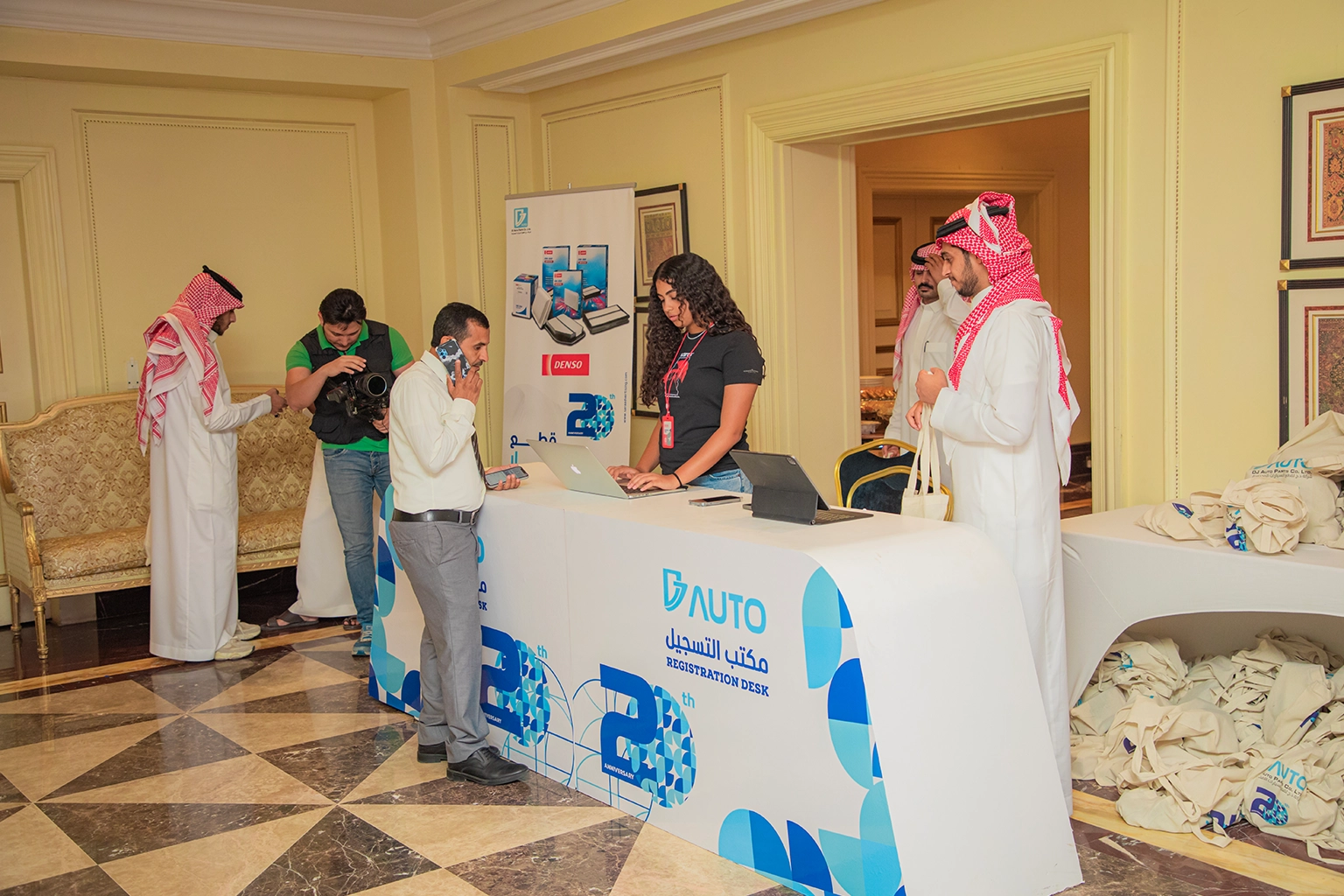 Branded delegate registration desk with staff checking in guests at a corporate event, showing managed arrival experience