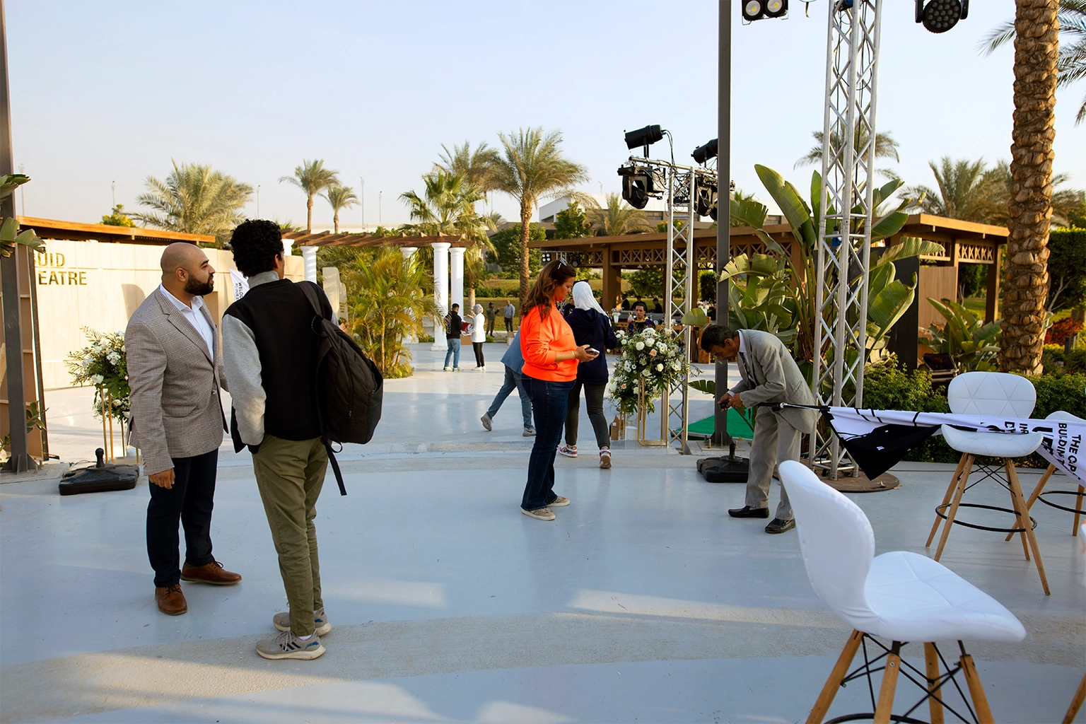 Event crew setting up an outdoor exhibition venue in Cairo with truss-mounted lighting rigs before doors open