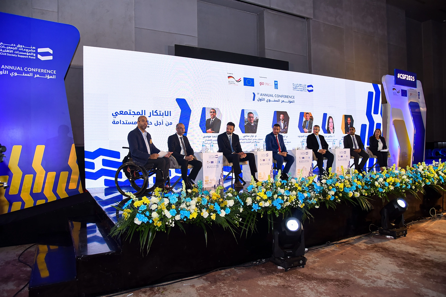 Multi-speaker panel on a branded stage at an institutional annual conference in Cairo with full AV production
